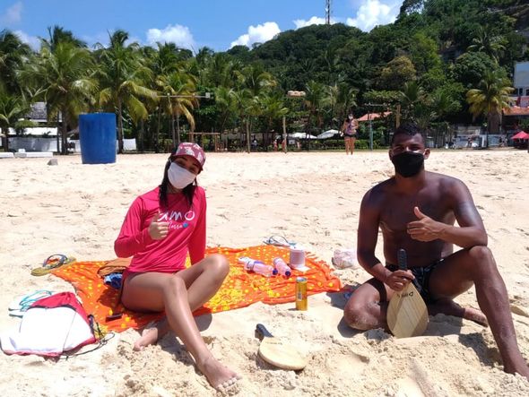 A enfermeira soteropolitana Lídia França, 25, e o recepcionista Iago Rocha, 24, usam máscara na praia e escolheram cantinho isolado em Morro de SP por Foto: Gess Alencar