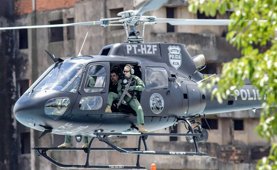 O líder do grupo criminoso Comando Vermelho, Marcelo Pinheiro (2-D), conhecido como "Piloto", é visto em um helicóptero de polícia do estado do Paraná, após ser expulso do Paraguai.  por AFP