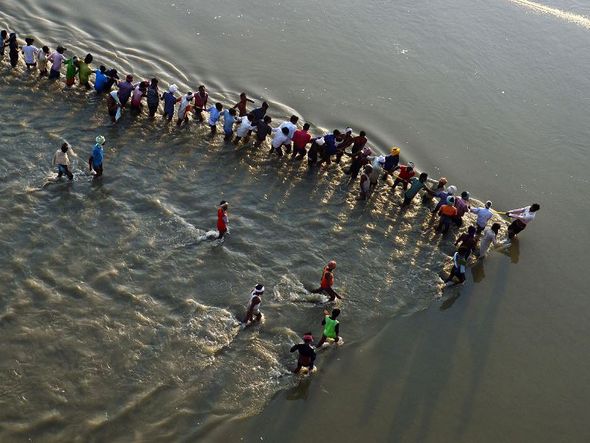 Cordão humano no rio Ganges para construção de uma ponte flutuante para o próximo festival de Kumbh Mela, em Allahabad.  por SANJAY KANOJIA / AFP