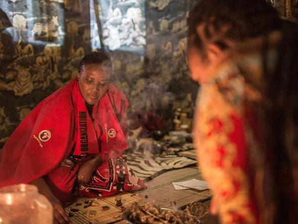 Gogo Phephisile Maseko, 44, curandeira tradicional e coordenadora nacional da organização de curandeiros tradicionais (THO) da África do Sul atende aos pacientes usando uma mistura de maconha e outras ervas. por GULSHAN KHAN / AFP