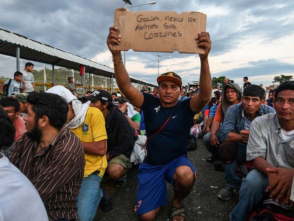 Migrante hondurenho, participando de uma caravana, indo para os EUA, leva uma placa onde se lê "Obrigado México para abrir seus corações para nós", enquanto espera atravessar a fronteira de da Guatemala, para Ciudad Hidalgo, no México. por ORLANDO SIERRA / AFP