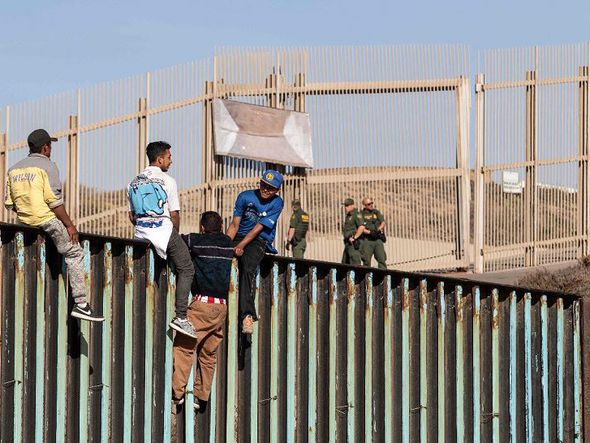 Migrantes de países centro-americanos, principalmente hondurenhos - se movem em direção aos Estados Unidos, são vistos perto da fronteira dos EUA em Playas de Tijuana, México. por GUILLERMO ARIAS/AFP
