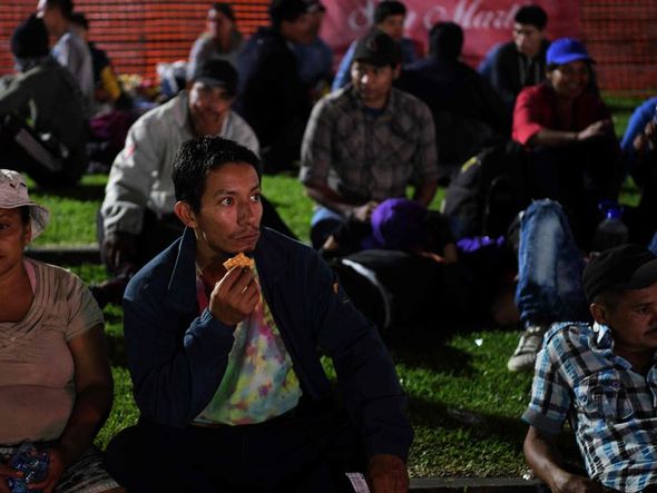 Migrantes salvadorenhos esperam na Praça "Salvador del Mundo", em San Salvador para se juntar à caravana de milhares de centro-americanos que rumam para os EUA. por MARVIN RECINOS / AFP