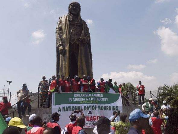 Os trabalhadores se reúnem em torno da estátua de crítico social nigeriano e político Gani Fawehinmi durante uma marcha de protesto contra o fracasso do governo chegar a acordo sobre um novo salário mínimo, em Lagos. por PIUS UTOMI EKPEI / AFP