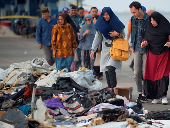 Parentes tentam identificar itens pessoais de entes queridos que estavam a bordo do avião da Lion Fly  que caiu no mar na Indonésia. por BAY ISMOYO / AFP