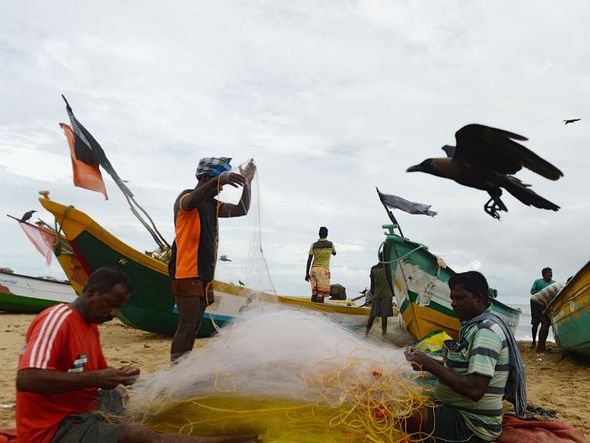 Pescadores na praia de Pattinapakkam, em Chennai, na Índia.  por ARUN SANKAR / AFP