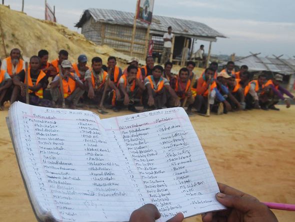 Trabalhadores Rohingya esperam para receber seus salários diários depois de trabalhar em uma construção de estrada no campo de refugiados de Kutupalong, em Ukhia, em Bangladesh. por DIBYANGSHU SARKAR / AFP