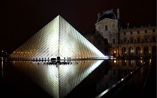 A pirâmide do Louvre iluminada à noite por BERTRAND GUAY / AFP