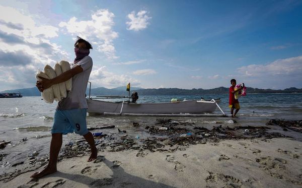Aldeões da Indonésia carregam provisões para a aldeia isolada de Lambonga em Donggala, após o terremoto e tsunami que alcançaram a região. A busca pelos mortos no desastre foi cancelada, apesar de haver 5.000 pessoas desaparecidas por MUHAMAD NASRUN / AFP