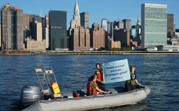 Ativistas do Greenpeace estendem um banner perto das Nações Unidas, para chamar a atenção para a campanha de santuários do  oceano. No East River em Nova York. por DON EMMERT / AFP