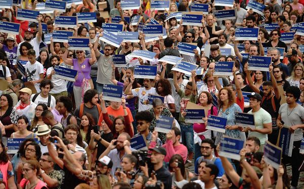 Manifestantes levam as placas de rua Marielle Franco durante uma homenagem no centro do Rio de Janeiro. por CARL DE SOUZA / AFP