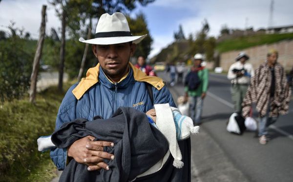 O venezuelano Richard Lomelle e seu bebê Tiago caminham ao longo da rodovia Pan-americana, entre Pasto e Ipiales, Colombia, no caminho para o Peru por LUIS ROBAYO / AFP