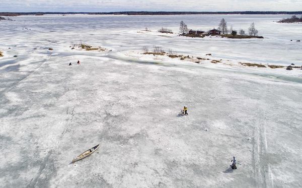 Pescadores no mar congelado de  Bjoerkoe, na ilha de Raipaluoto, na Finlândia. por OLIVIER MORIN/AFP