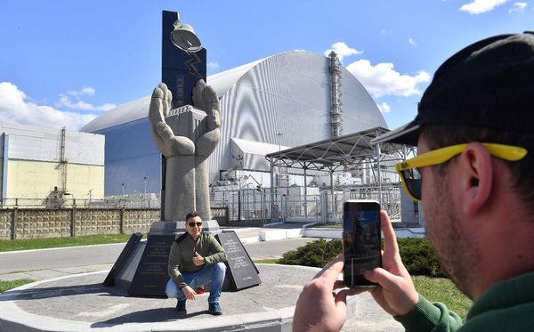 Turistas em visita a Usina de Chernobyl na Ucrânia, onde a 32 anos ocorreu o maior desastre de vazamento de energia nuclear. por SERGEI SUPINSKY/AFP