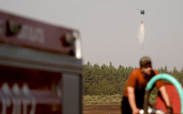 Um helicóptero joga leva água de um lago para conter o fogo em Kauhava,na Finlândia.  A área atingida é de aproximadamente 80 hectares. por LEHTIKUYA/AFP