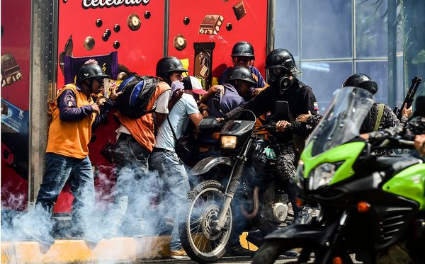 Manifestantes e a polícia venezuelana entram em conflito durante prostesto da oposição em Caracas. por Ronaldo Schemidt/AFP