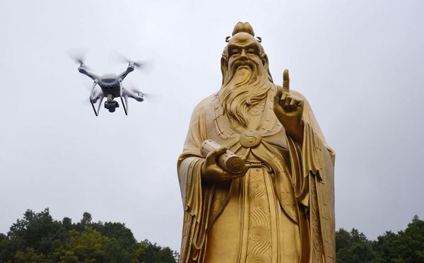 Mini aeronave  sobrevoa a estátua de Lord Laozi durante a Convenção de Drones na Montanha de Laojun em Luoyang, na província de Henan na China central.  por STR / China Out/AFP