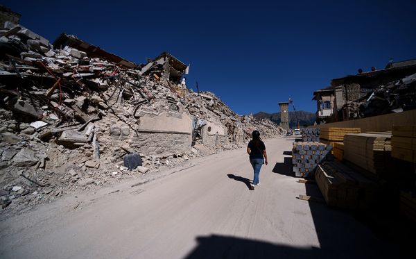 Mulher passeia pela cidade de Amatrice, Itália vítimas. por Filippo Monteforte/AFP