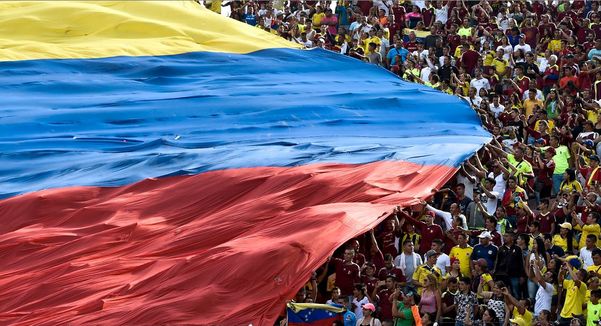 Torcedores venezuelanos estendem a bandeira nacional durante o jogo classificatório para a Copa 2018 em San Cristobal. por Juan Barreto/AFP 