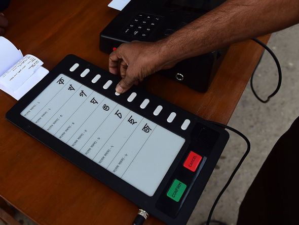 Funcionários da Comissão de eleições um Bangladesh demonstram  como usar uma máquina de votação eletrônica (EVM) em Dhaka.  por MUNIR UZ ZAMAN / AFP