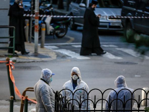 Investigadores gregos fazem a perícia no local onde houve a explosão de uma bomba do lado de fora de uma igreja ortodoxa, no centro de Atenas ferindo um policial. por EUROKINISSI/AFP  