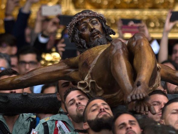 Membros da Legião Espanhola carregam uma estátua representando "El Cristo de la Buena Muerte" (o Cristo da boa morte) na Igreja de Santo Domingo de Guzman durante a procissão da semana Santa do 'Cristo de Mena' em Málaga, no sul da Espanha.  por JORGE GUERRERO / AFP