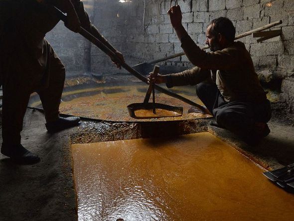 Trabalhadores afegãos preparam açúcar mascavo em uma tradicional fábrica na província de Kama, distrito de Nangarhar, a leste de Jalalabad. por NOORULLAH SHIRZADA / AFP