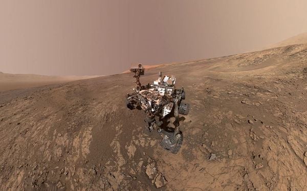 Veículo rover da NASA em Marte em Vera Rubin Ridge. Atrás do rover, a cratera Gale.   por NASA/AFP