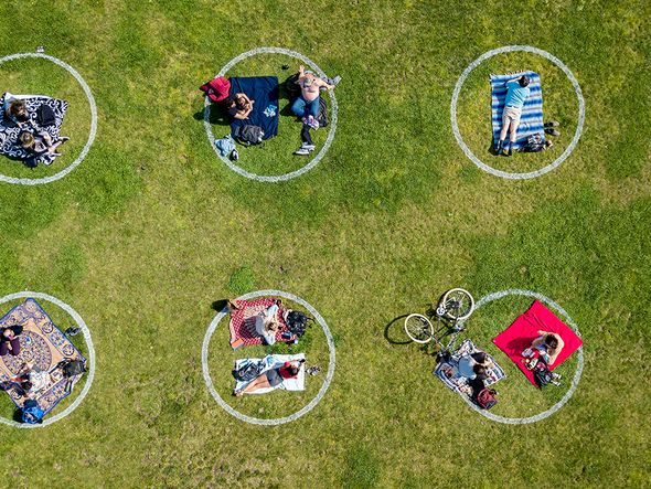 Vista aérea mostra pessoas reunidas dentro de círculos pintados na grama, incentivando o distanciamento social no Dolores Park, em São Francisco, Califórnia. por Josh Edelson/AFP