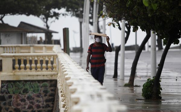 Em dia chuvoso, homem caminha pela orla da Barra por Arisson Marinho/COOREIO