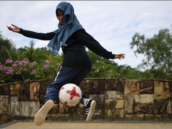 A jogadora de futebol freestyle Qhouirunnisa' Endang Wahyudi, 18, controla a bola em um parque em Klang, nos arredores de Kuala Lumpur.  por MOHD RASFAN/AFP