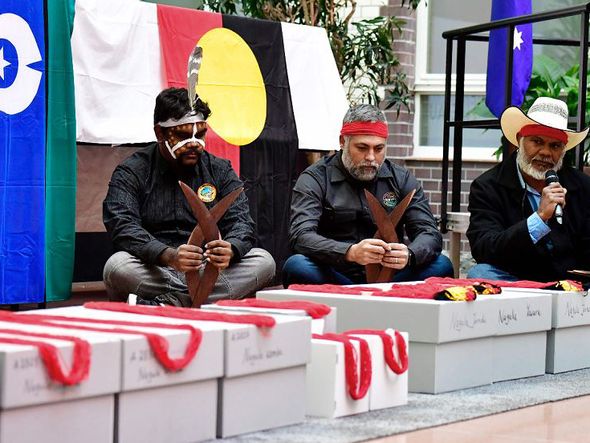 Aborígenes australianos, incluindo Neil McKenzie (D) da comunidade de Yawuru participam em Berlim  da  cerimônia de repatriamento dos restos mortais de ancestrais indígenas que estavam em museus alemães da saxônia. por TOBIAS SCHWARZ / AFP