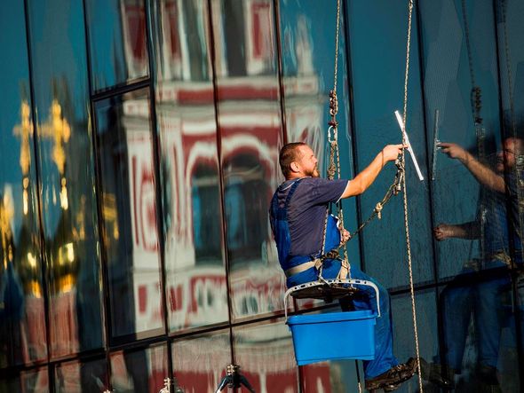 Limpeza de vidraças na Praça vermelha  por ODD ANDERSEN/AFP
