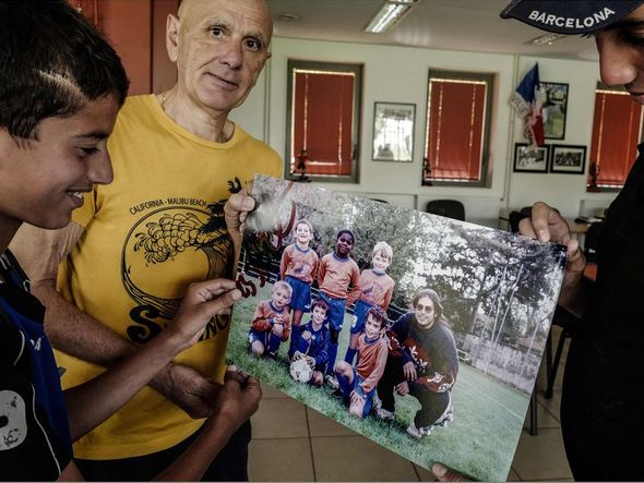 Treinador Alain Gonnard o Menival, mostra foto do time MFC, de Lyon,  em que o goleiro da seleção francesa Samuel Umtiti começou a jogar. por JEAN-PHILIPPE KSIAZEK/AFP