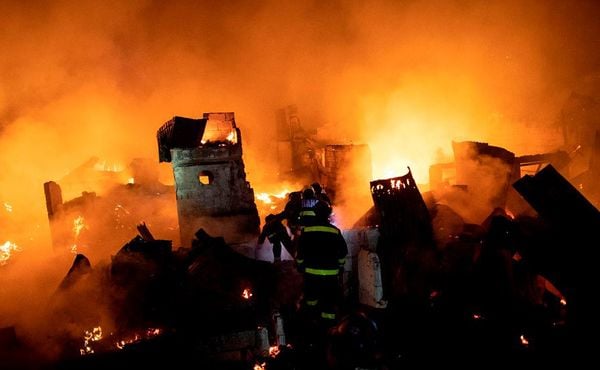 Bombeiros tentam apagar o fogo que engoliu uma área de favela em Manila, deixando cerca de 300 casas e 400 famílias desabrigadas. por NOEL CELIS / AFP