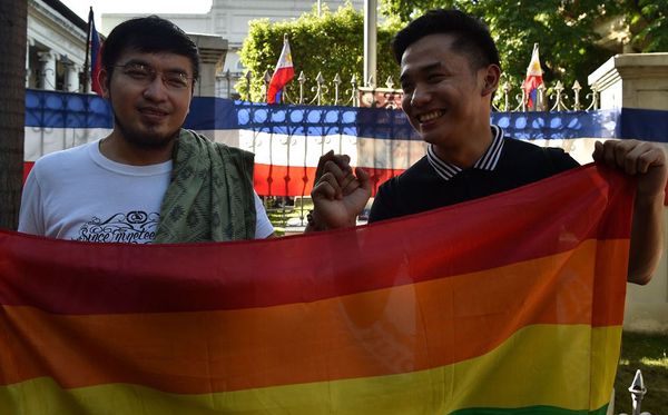 Casal LGBT marca presença em frente a Suprema Corte de Manila, onde o Tribunal superior das Filipinas coleta argumentos para a legalização do casamento gay.