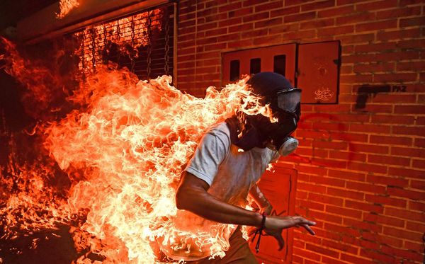 Foto ganhadora do World Press Photo 2018, da autoria do fotógrafo venezuelano Ronaldo Schemidt, mostra um manifestante pegando fogo durante os protestos anti-governamentais em Caracas.  por RONALDO SCHEMIDT/AFP
