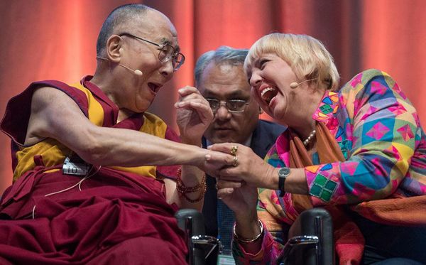 Líder espiritual tibetano o Dalai Lama sorri com Claudia Roth (R), vice-presidente do Bundestag (câmara baixa do Parlamento) durante o Simpósio "não-violência é o caminho", em Darmstadt, Alemanha Ocidental. por BORIS ROESSLER/AFP