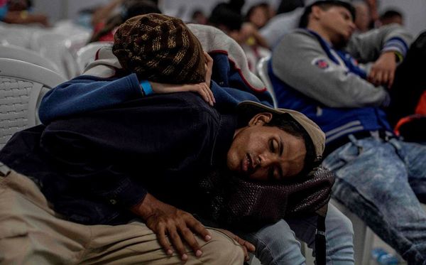 Migrantes venezuelanos que vivem em Medellin, na Colômbia, dormem na fila de emprego. por JOAQUIN SARMIENTO / AFP