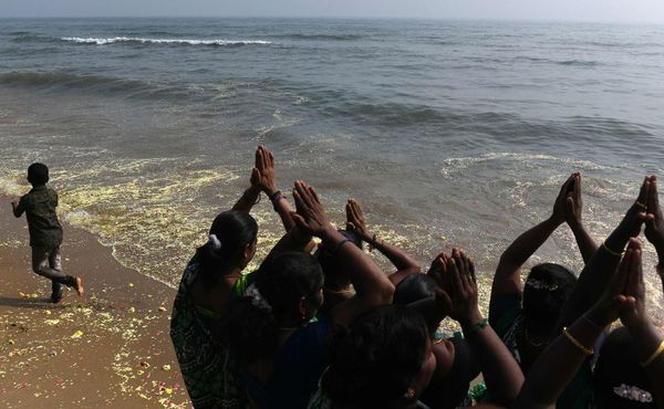 Mulheres fazem orações para as vítimas do tsunami de 2004 na praia de Pattinapakkam em Chennai. O terremoto e o tsunami que atingiu o Oceano Índico em 26 de dezembro de 2004 mataram quase 230.000 pessoas. por ARUN SANKAR / AFP