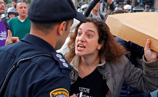 Mulheres israelenses enfrentam a polícia durante uma manifestação contra a violência  doméstica na cidade costeira mediterrânica de Tel Aviv.  por JACK GUEZ / AFP
