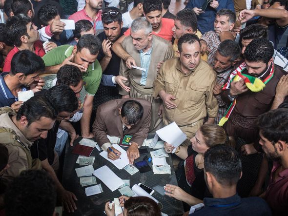 Eleitores conferem títulos para participar do referendo para independência dos Curdos no Iraque.  por Ahmed Deeb/ AFP