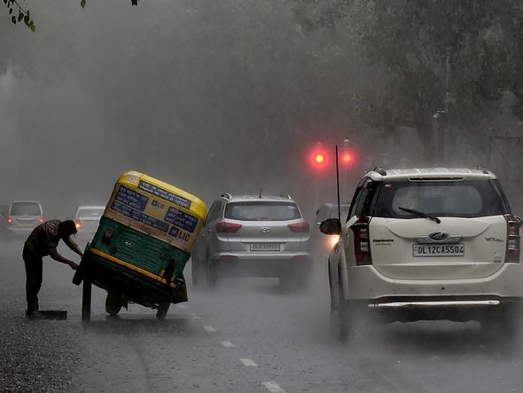 Motoristas enfrentam chuva forte em Nova Déli, Índia. por Money Sharma/ AFP