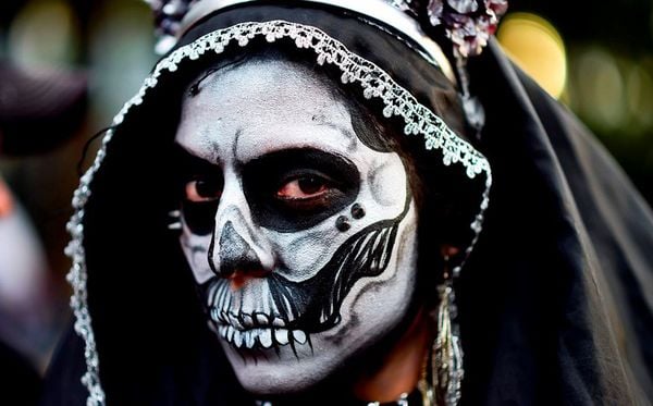 A maquiagem da La Catrina, caveira estilizada que representa a morte, invade as ruas da cidade do México na semana de comemoração do Dia dos Mortos  por Ronaldo Schemidt/AFP 