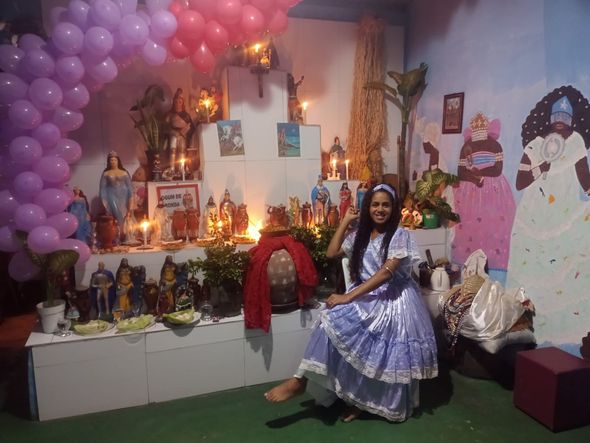 Ialorixá Develyn Almeida Santos em frente ao altar por Foto: Arquivo Pessoal