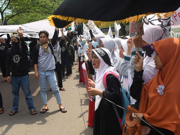 Mulçumanos da Indonésia marcham para celebrar o 52º aniversário da morte de seis generais e um tenente durante um golpe mal-sucedido ao Presidente Sukarno em Jacarta.  por Goh Chai Chin/AFP 