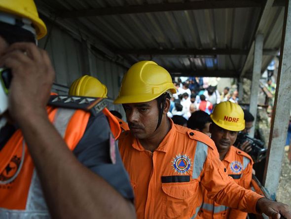 Tulmulto de origem ainda não identificada provocou uma correria na passarela ferroviária de Mumbai causando a morte de 15 pessoas. Socorristas chegam para efetuar o resgate dos sobreviventes.  por Punit Paranjpe/AFP 