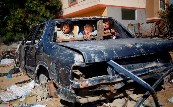 Crianças palestinas brincam em carro abandonado em Beit Hanun no norte da Faixa de Gaza por MOHAMMED ABED/AFP