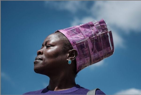 Joyce Adhiambo, ativista da prevenção contra a HIV AIDS e Tuberculose veste um turbante criado com embalagens de preservativos femininos em evento comemorativo ao Dia Mundial de Combate à AIDS na Universidade de Nairobi.  por YASUYOSHI CHIBA/AFP 