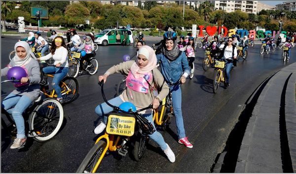 Mulheres sírias participam de um passeio ciclístico em apoio a campanha sobre a violência contra a mulher em Damasco.  por LOUAI BESHARA/AFP